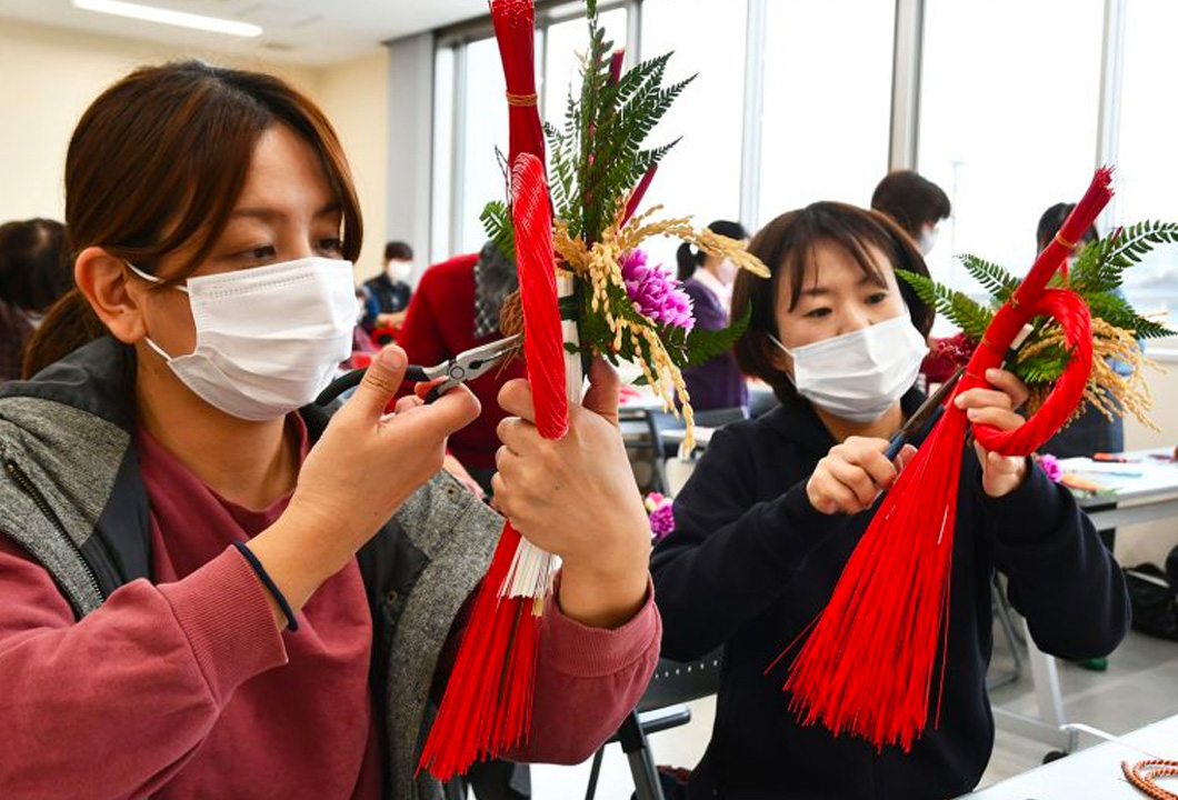 水引を使った正月飾り作りに励む参加者