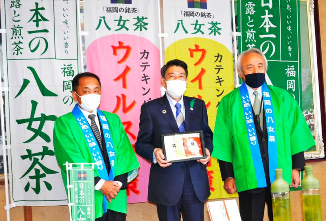 「福岡の八女茶」ロゴマーク付きティーバッグを贈呈した藏内会長（写真㊨）、江島部会長（写真㊧）と服部誠太郎県知事（写真㊥）