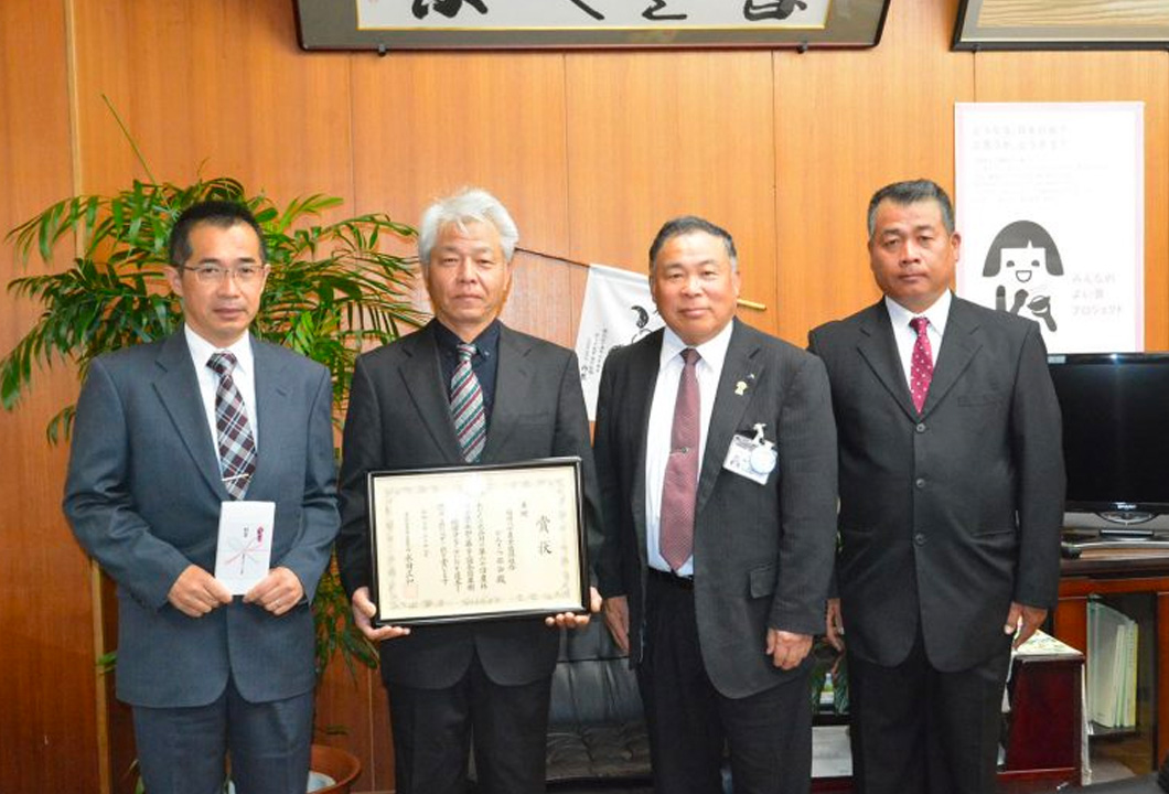 鵜木髙春組合長へ受賞報告したかんきつ部会役員ら(左から古賀浩輝副部会長、松﨑部会長、鵜木組合長、中島光秀副部会長)