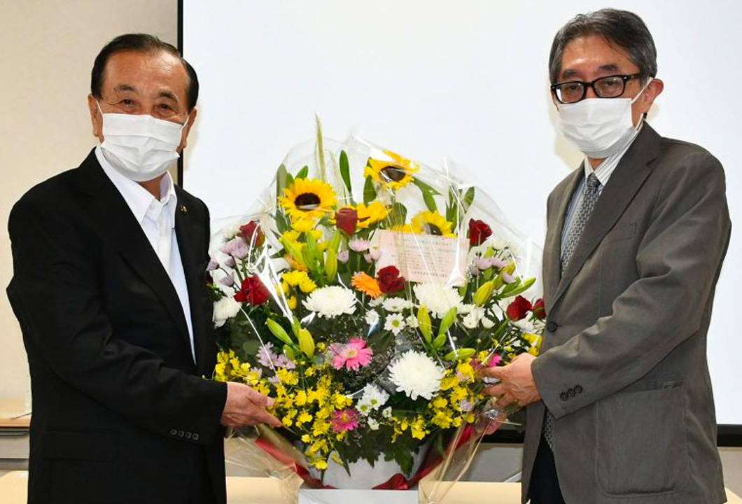 長崎院長（写真㊨）にフラワーアレンジメントを贈呈する三田村市長